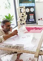 An expert artisan practicing traditional hand embroidery